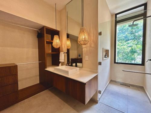 a bathroom with a sink and a mirror at TOH Tulum - 2 Bedroom Apartments - Fiber WiFi in Tulum
