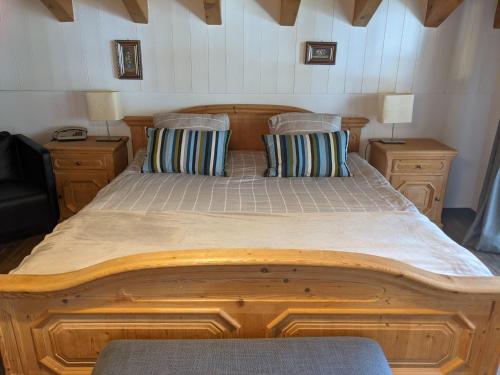 a large wooden bed with two pillows on it at Hotel Beau-Séjour in Leukerbad