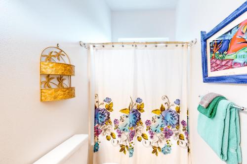 uma casa de banho com uma cortina de chuveiro com flores em JS Beach House em Lincoln City