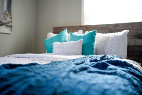 a bed with blue and white pillows on it at 1 Bedroom Stylish Oasis in Omaha