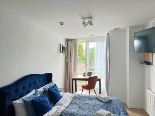 a bedroom with a blue bed and a table at Great Polonia River Boat Apartments Wrocław in Wrocław