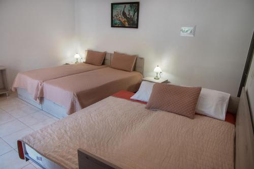 a bedroom with two beds and two lamps on tables at Antartisa B&B in Límni