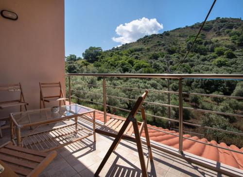 a balcony with a table and chairs and a mountain at Antartisa B&B in Límni