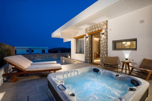 a jacuzzi tub in the backyard of a house at Lithos Luxury Villa in Archangelos