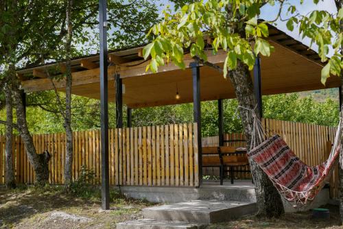 - un hamac suspendu à un arbre devant un pavillon dans l'établissement Racha Twins, à Nikortsminda