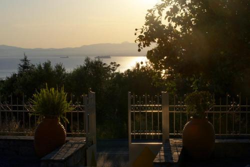 a gate with a view of the ocean at sunset at Iliovasilema in Mírton