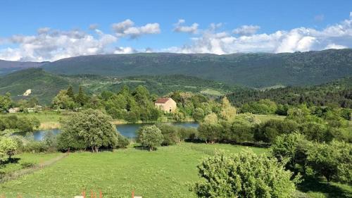 a house in a field next to a lake at Racha Twins in Nikortsminda