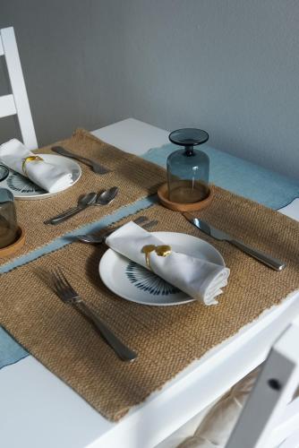 a table with plates and utensils on a table at A Casa de Cima - Cacela Velha in Vila Nova De Cacela