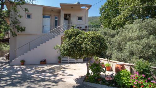 a house with stairs and flowers in front of it at Antartisa B&B in Límni