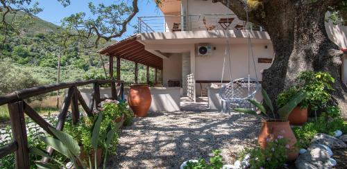a house with a tree and a swing at Antartisa B&B in Límni