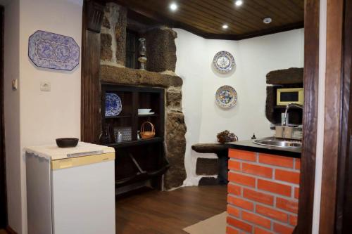 a kitchen with a stove and a sink in a room at Casa Velha do Fumeiro in Santa Eulália