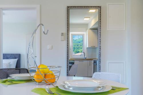a dining room table with a mirror and a bowl of fruit at Emilia Lofts in Tučepi