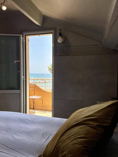 a bedroom with a bed and a view of the ocean at Hotel La Calanque in Mandelieu-la-Napoule