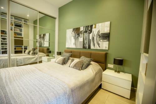 Spacious studio apartment Sliema في سليمة: غرفة نوم بسرير ومرايا كبيرة