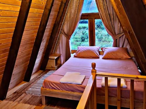 a bedroom with a bed in a room with a window at Life on the farm in Nepravishtë