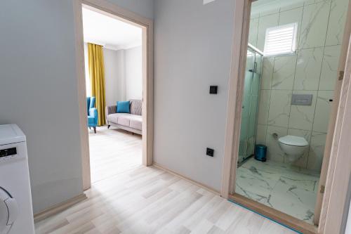 a bathroom with a shower and a toilet and a mirror at Flora Trabzon Apart in Pelitli
