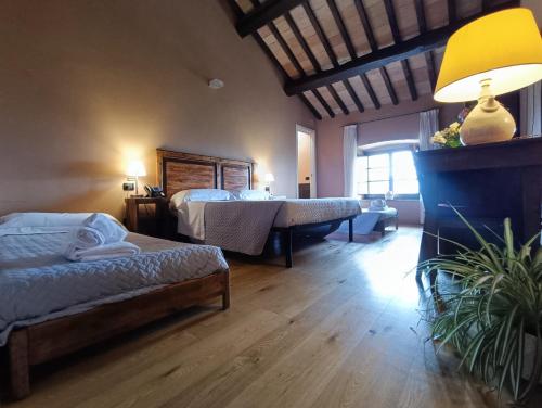 a bedroom with two beds and a lamp in it at Castello di Baccaresca in Branca