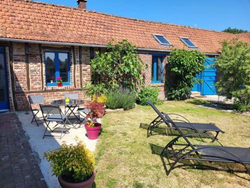 une maison avec des chaises et une table dans une cour dans l'établissement Studio à 15 minutes des falaises et proche des étangs, à Dargnies
