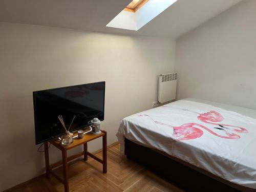 Schlafzimmer mit einem Bett und einem Flachbild-TV in der Unterkunft JANA in Veliko Gradište