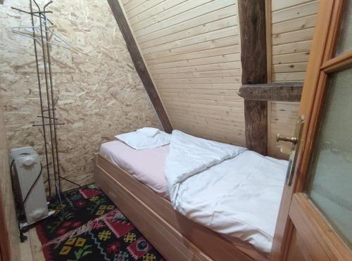 a small bed in a corner of a room at Na krovu svijeta in Lukomir