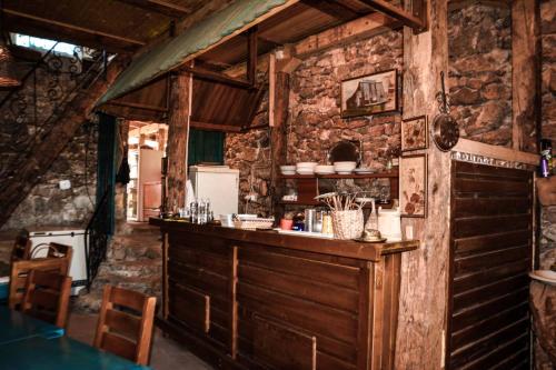 a kitchen with a bar in a stone wall at Na krovu svijeta in Lukomir
