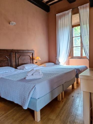 a bedroom with two beds and a window at Castello di Baccaresca in Branca
