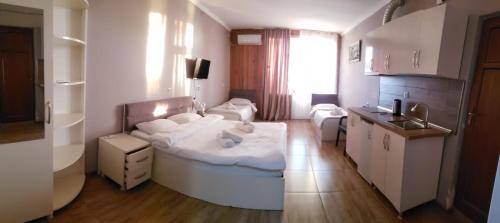 a small room with a bed and a kitchen at MIDIA Guest House in K'obulet'i