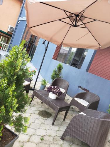 a patio with a table and chairs and an umbrella at MIDIA Guest House in K'obulet'i
