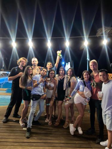 a group of people posing for a picture on a stage at The Point Mancora - Beach Party Hostel in Máncora