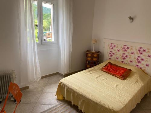 ein Schlafzimmer mit einem Bett mit einem roten Kissen darauf in der Unterkunft Maison tranquillité in Montégut-Plantaurel
