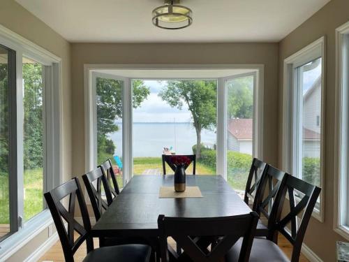 comedor con mesa con sillas y ventana grande en The Waterfront Paradise, en Orillia