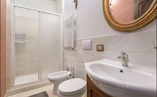 uma casa de banho com um lavatório, um WC e um espelho. em Residenza Sinibaldi em Roma