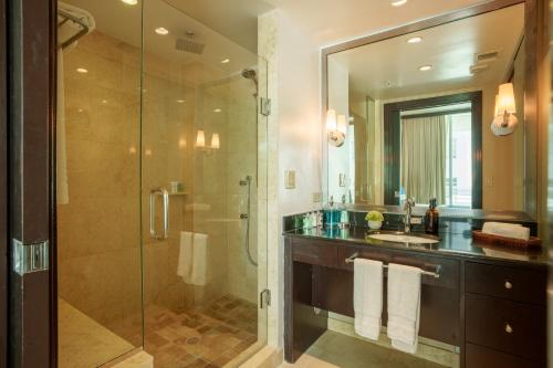 uma casa de banho com uma cabina de duche em vidro e um lavatório. em Boutique Suites 3 min walk to beach em Miami Beach