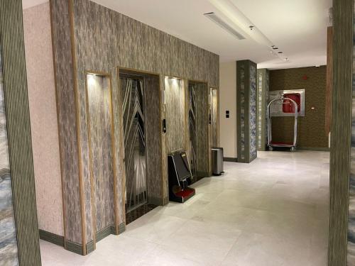 a hallway in a building with a wall with a fireplace at فندق حياة تاون 2 in Umm Lujj