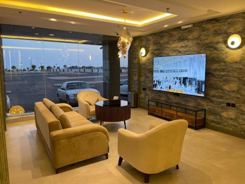 فندق حياة تاون 2 في أملج: غرفة معيشة مع أريكة وكراسي وتلفزيون