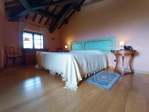 a bedroom with a large bed and a wooden floor at Castello di Baccaresca in Branca