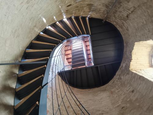 a spiral staircase in a building with a window at Castello di Baccaresca in Branca