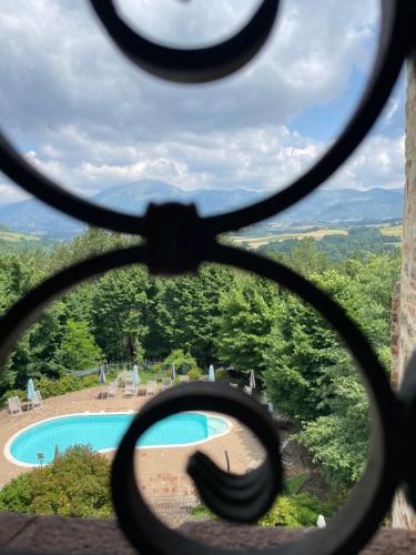 a view of a swimming pool through a pair of scissors at Castello di Baccaresca in Branca