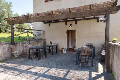 a patio with tables and chairs under a wooden pergola at B&B Le Torri Di Firenze in Fiesole