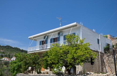 ein weißes Gebäude mit Balkon darüber in der Unterkunft Magdas house in Alonnisos Altstadt