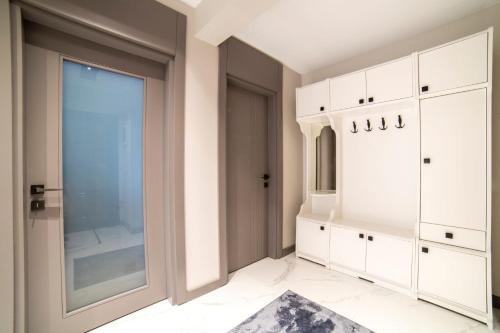 een badkamer met witte kasten en een groot raam bij Stile Suite Large House, Konyaalti ,500 meters on the beach in Antalya