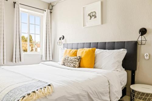 een slaapkamer met een bed met gele en witte kussens bij Stylish City Retreat - King Beds - Walk to Sloans Lake in Denver