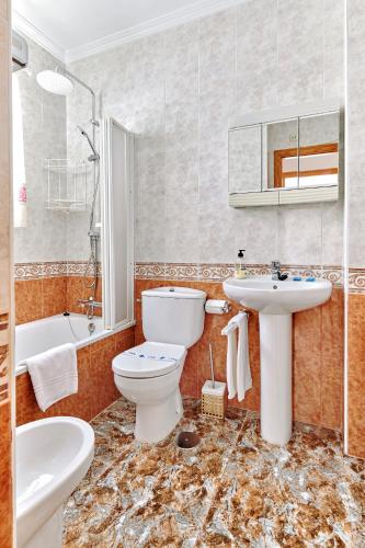 a bathroom with a toilet and a sink and a tub at Espanhouse Alina in Orihuela Costa