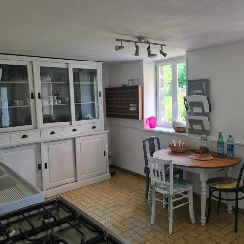 a kitchen with a table and chairs and a dining room at La Balnière Normande in Hambye