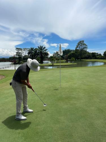 une personne joue au golf sur un parcours dans l'établissement Lake House Resort Country Club & Spa, à Santander de Quilichao