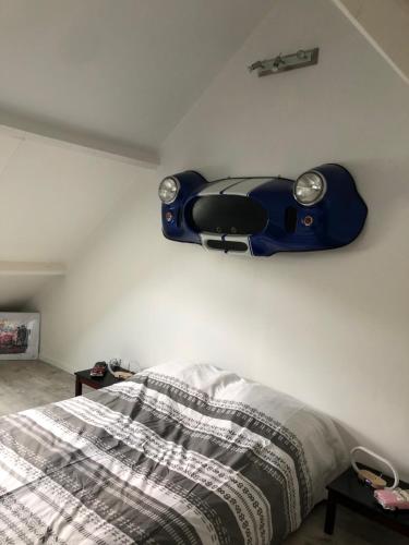- une chambre avec un lit et une guitare bleue sur le mur dans l'établissement Le Domaine d'Angélique, à La Vespière