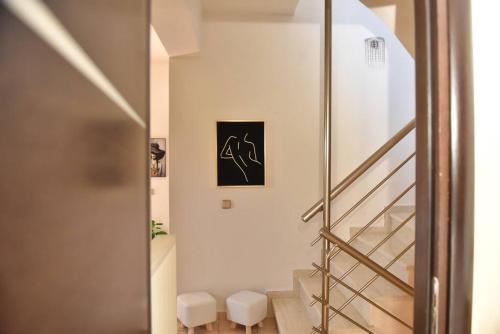 un pasillo con una escalera con dos taburetes en Villa Emmanuel, en Karteros