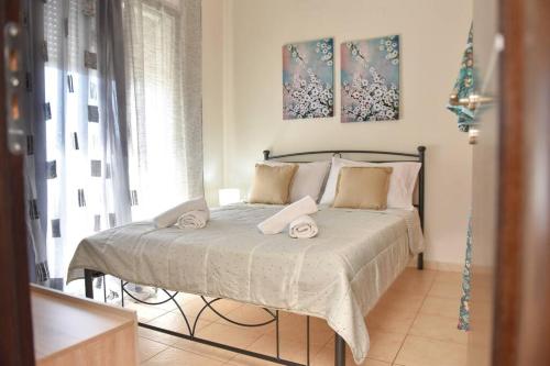 een slaapkamer met een bed met twee handdoeken erop bij Villa Emmanuel in Karteros