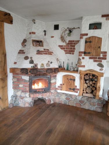 a living room with a stone fireplace in a house at Chatka skrzatka in Kruki