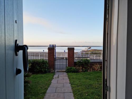 a door to a house with a view of the ocean at Beach View Couples Retreat Aberavon Beach Direct Seafront panoramic Sea Views large driveway parking in Port Talbot